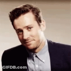 A Man In A Suit And Blue Shirt Is Making A Face . GIF