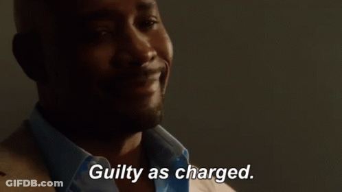 A Man In A Suit And Blue Shirt Is Smiling And Says Guilty As Charged GIF