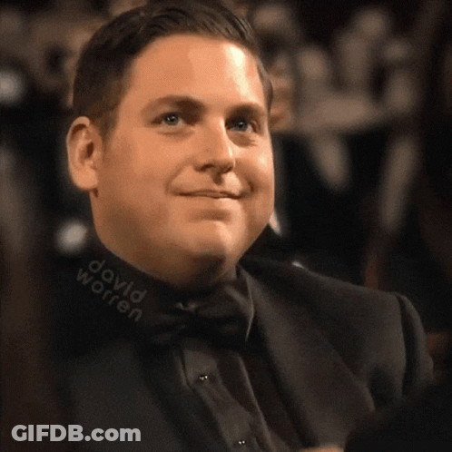 A Man In A Suit And Bow Tie Has David Worren Written On His Collar GIF