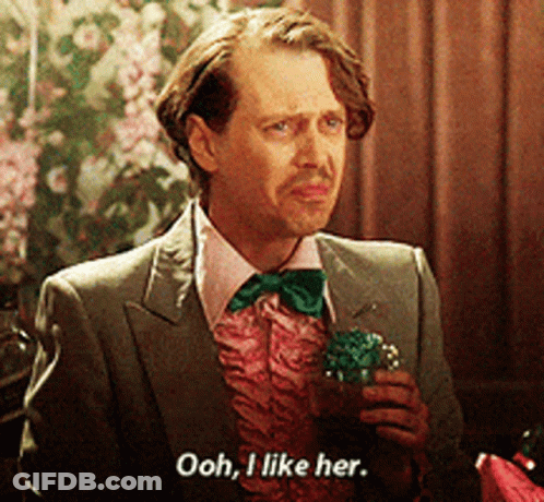 A Man In A Suit And Bow Tie Is Holding A Cupcake And Saying Ooh I Like Her GIF