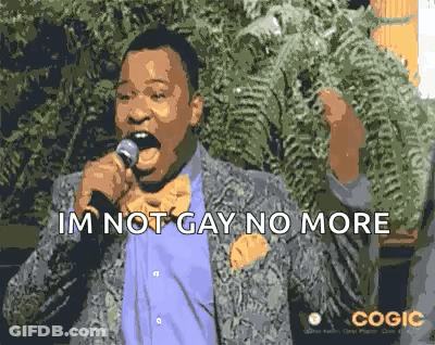 A Man In A Suit And Bow Tie Is Singing Into A Microphone And Saying `` Im Not Gay No More '' . GIF