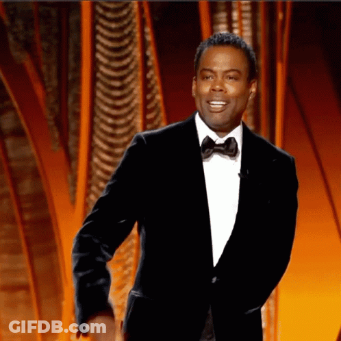 A Man In A Suit And Bow Tie Is Smiling GIF