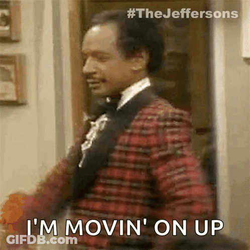 A Man In A Suit And Bow Tie Is Standing In A Doorway And Says `` I 'M Movin ' On Up '' GIF