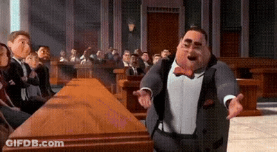 A Man In A Suit And Bow Tie Is Standing In Front Of A Courtroom . GIF