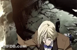 A Man In A Suit And Bow Tie Is Standing In Front Of A Destroyed Building GIF