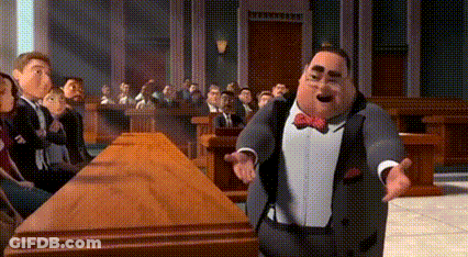 A Man In A Suit And Bow Tie Is Standing In Front Of A Group Of People . GIF