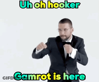 A Man In A Suit And Bow Tie Is Standing In Front Of A White Background With The Words Gamrot Is Here GIF