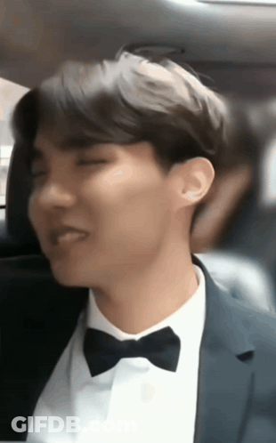 A Man In A Suit And Bow Tie Sitting In A Car GIF