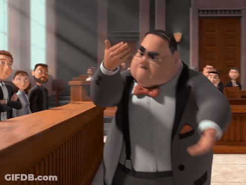 A Man In A Suit And Bow Tie Stands In Front Of A Jury GIF