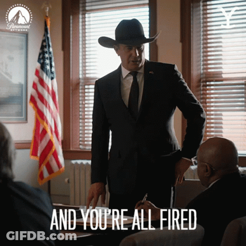 A Man In A Suit And Cowboy Hat Says " And You 'Re All Fired " In Front Of An American Flag GIF