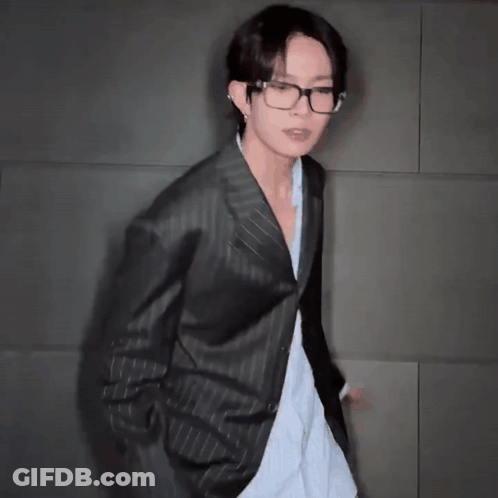 A Man In A Suit And Glasses Is Dancing GIF