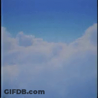 A Man In A Suit And Glasses Is Floating In The Clouds . GIF