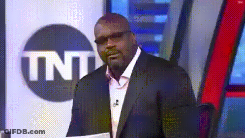 A Man In A Suit And Glasses Is Standing In Front Of A Tnt Logo GIF