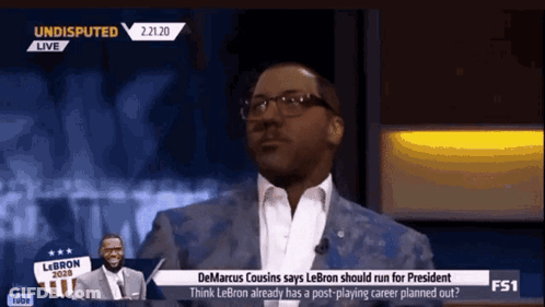 A Man In A Suit And Glasses Is Talking On A Tv Show Called Undisputed GIF