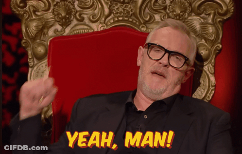 A Man In A Suit And Glasses Sits In A Red Chair With The Words Yeah Man Above Him GIF