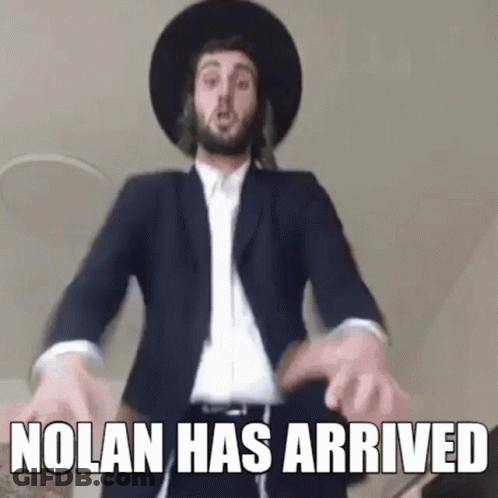 A Man In A Suit And Hat Is Dancing With The Words `` Nolan Has Arrived '' . GIF