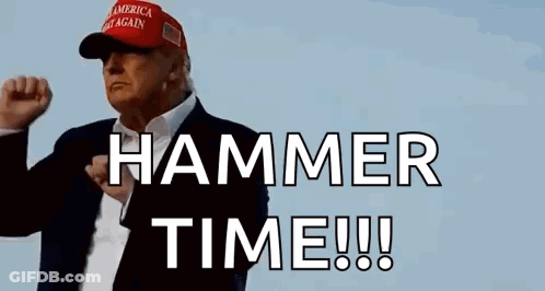 A Man In A Suit And Hat Is Holding His Fist Up In The Air . GIF
