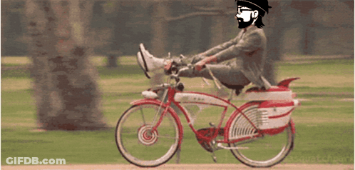A Man In A Suit And Hat Is Riding A Red And White Bicycle GIF
