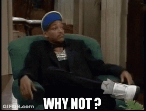 A Man In A Suit And Hat Is Sitting In A Chair With His Legs Crossed And Says `` Why Not ? '' . GIF