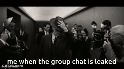 A Man In A Suit And Hat Is Surrounded By A Crowd Of People And The Caption Says Me When The Group Chat Is Leaked GIF