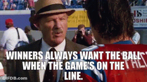 A Man In A Suit And Hat Is Talking To A Man In A Red Shirt . GIF