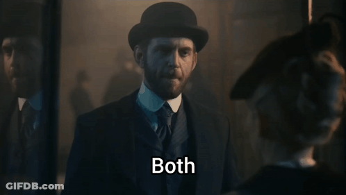 A Man In A Suit And Hat Says Both In A Dark Room GIF