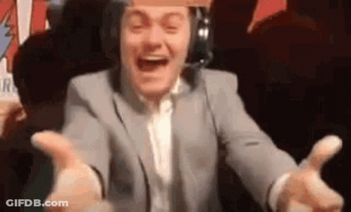 A Man In A Suit And Headphones Is Laughing With His Arms Outstretched In Front Of A Crowd . GIF