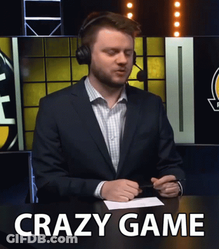 A Man In A Suit And Headphones Sitting At A Table With The Words Crazy Game Written On The Bottom GIF