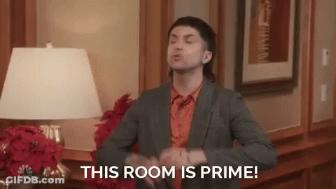 A Man In A Suit And Orange Shirt Is Saying This Room Is Prime . GIF