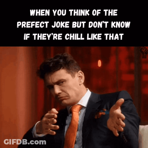 A Man In A Suit And Orange Tie Is Making A Funny Face GIF