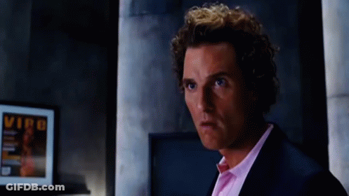 A Man In A Suit And Pink Shirt Is Standing In Front Of A Framed Picture That Says Vip On It GIF