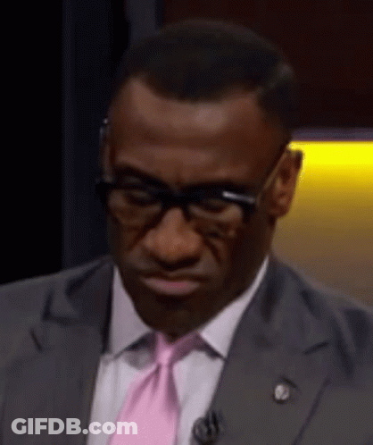 A Man In A Suit And Pink Tie Is Making A Face . GIF