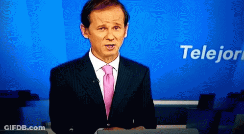A Man In A Suit And Pink Tie Is Standing In Front Of A Blue Background That Says Telejon GIF