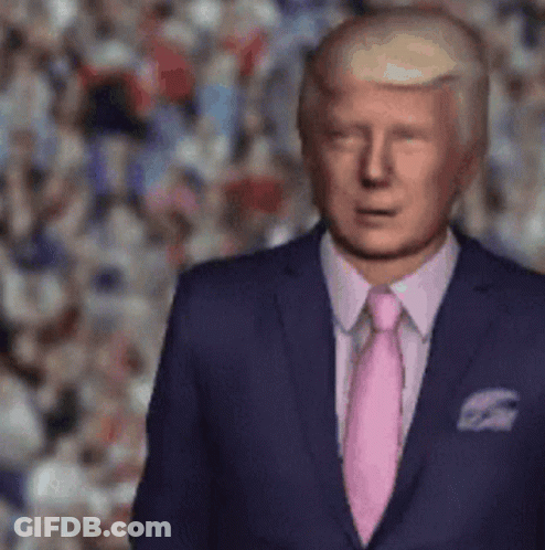 A Man In A Suit And Pink Tie Stands In Front Of A Crowd . GIF
