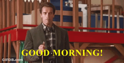 A Man In A Suit And Plaid Shirt Is Holding A Cane In Front Of A Sign That Says " Good Morning " GIF