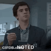 A Man In A Suit And Plaid Shirt Is Holding A Pen And A Clipboard . GIF