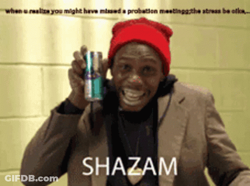 A Man In A Suit And Red Hat Holds A Can Of Shazam GIF