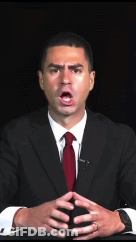 A Man In A Suit And Red Tie Is Making A Surprised Face GIF
