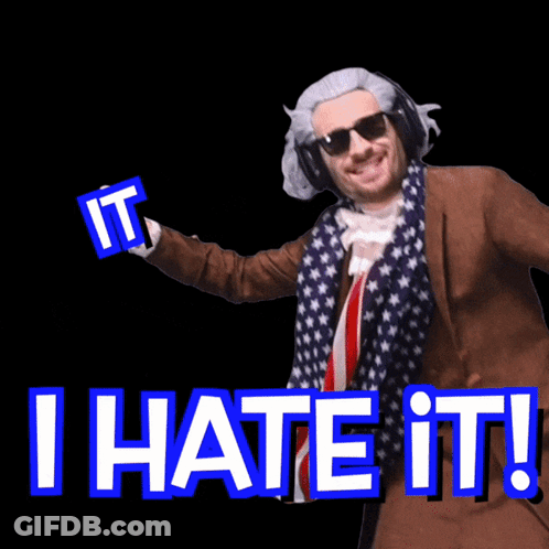 A Man In A Suit And Scarf Is Holding A Sign That Says I Hate It GIF