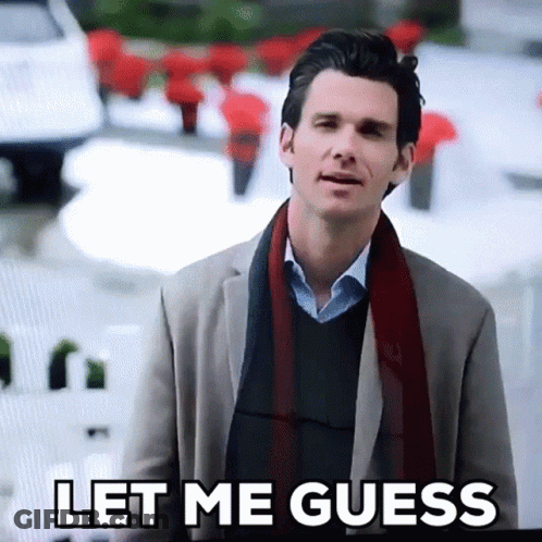 A Man In A Suit And Scarf Is Standing In Front Of A Sign That Says Let Me Guess GIF