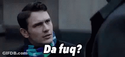 A Man In A Suit And Scarf Is Talking To Another Man While Wearing A Scarf . GIF