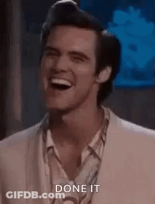 A Man In A Suit And Shirt Is Laughing And Saying Done It . GIF
