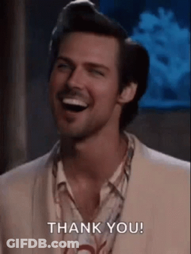 A Man In A Suit And Shirt Is Laughing And Saying Thank You . GIF