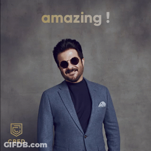 A Man In A Suit And Sunglasses Gives A Thumbs Up In Front Of An Amazing Sign GIF