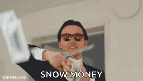 A Man In A Suit And Sunglasses Is Holding A Bunch Of Money And Cutting It With Scissors . GIF
