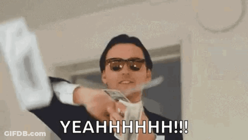 A Man In A Suit And Sunglasses Is Holding A Bunch Of Money . GIF