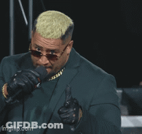 A Man In A Suit And Sunglasses Is Pointing A Gun At The Camera With The Caption Pew GIF