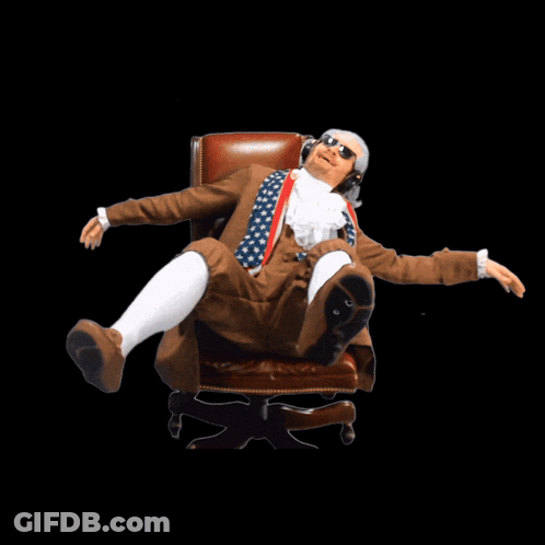 A Man In A Suit And Sunglasses Is Sitting In A Chair With His Arms Outstretched GIF