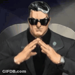 A Man In A Suit And Sunglasses Is Sitting In A Chair With His Hands Folded In Front Of Him . GIF