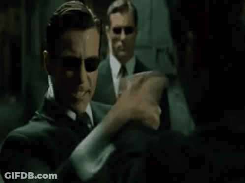 A Man In A Suit And Sunglasses Is Talking To Another Man In A Mirror And Says `` Hm , Upgrades '' . GIF